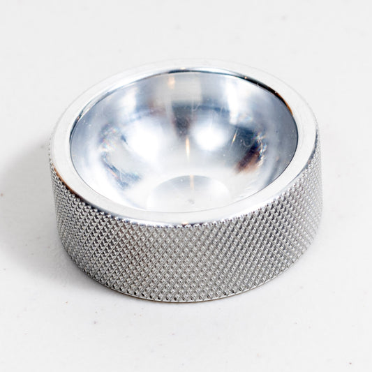Solid aluminum 2 inch ring dish with a knurled edge and polished bowl, angled view on white