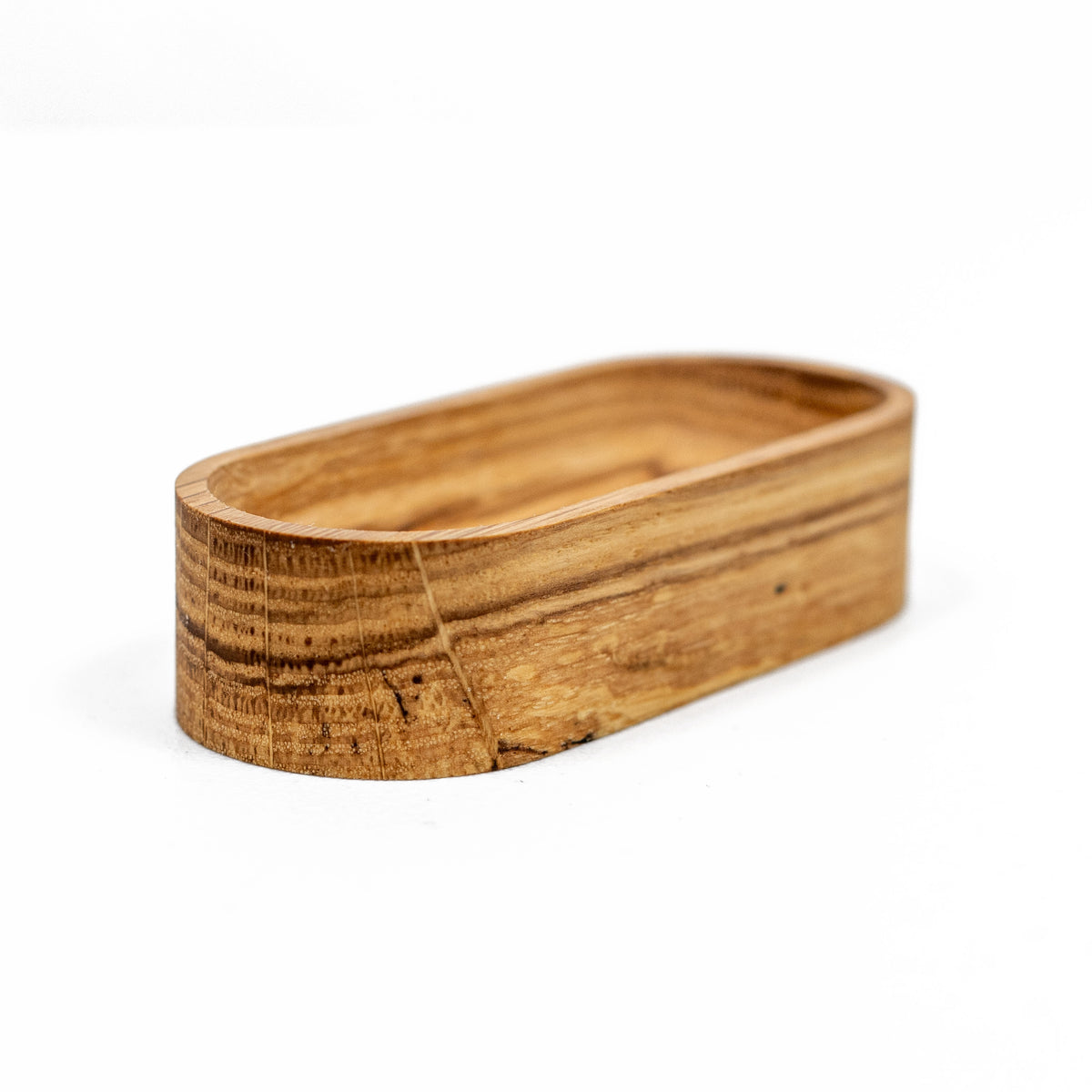 Solid oak 4 x 2 inch oval ring dish, empty, front angle on white